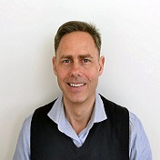 En mann som smiler til kameraet