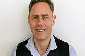 En mann som smiler til kameraet