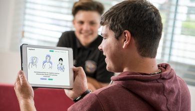 Ungdom holder ipad med selvhelpsverktøyet Ung Face It
