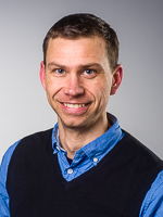 En mann som smiler til kameraet