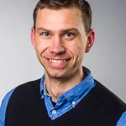 En mann som smiler til kameraet