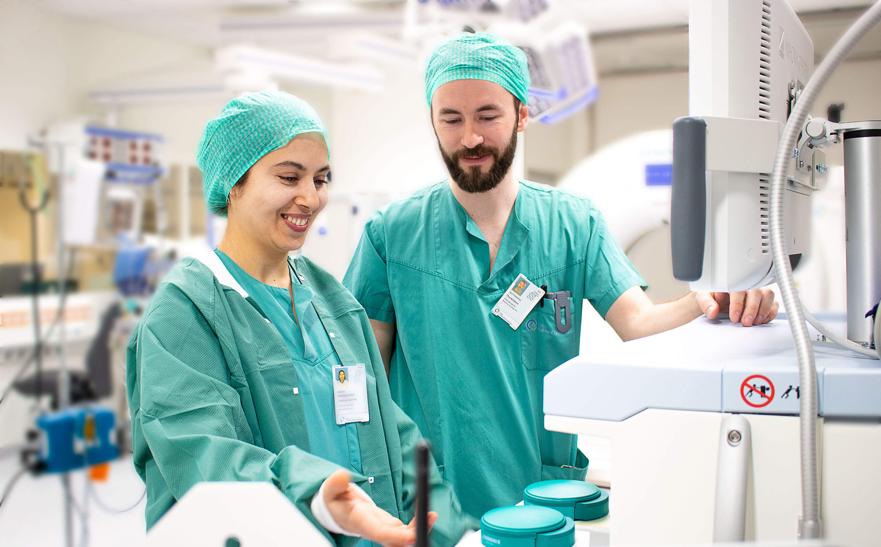 To sykehusansatte, Matin og Lars, ikledd grønt i et laboratorium.