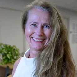 En kvinne som smiler til kameraet