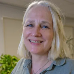 En kvinne som smiler til kameraet
