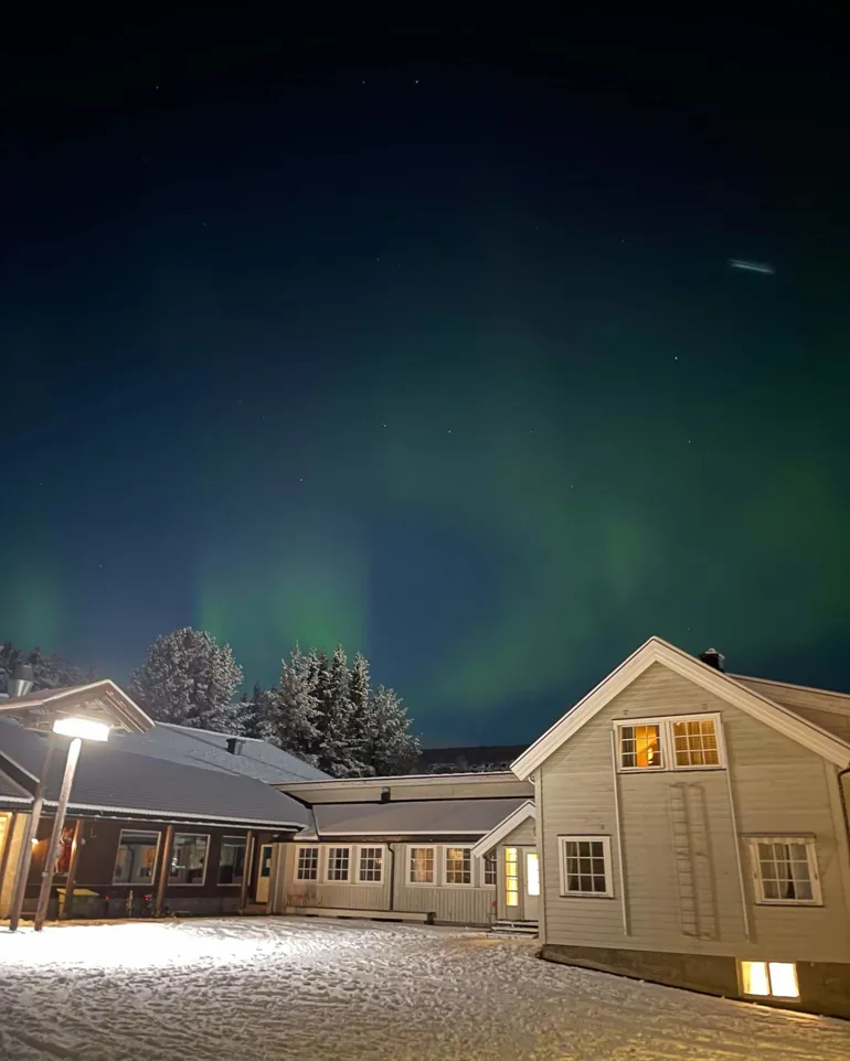 Nordlys over huset på Geilomo. Det er natt og vinter.