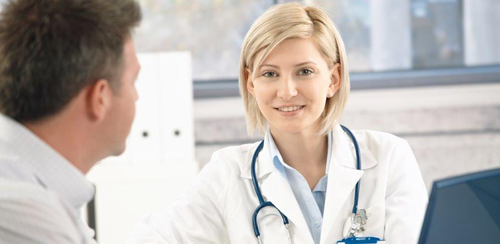 En lege som snakker med en pasient