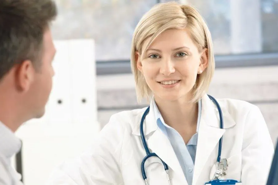 En lege som snakker med en pasient