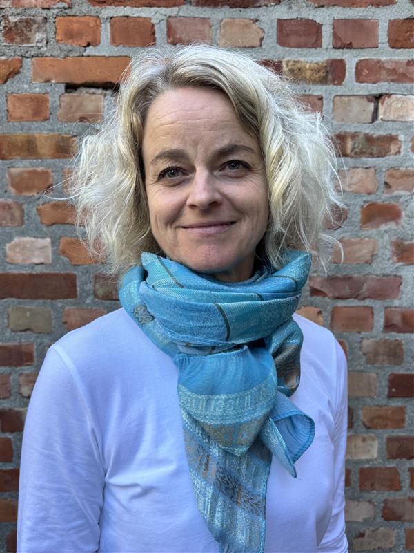 En kvinne som smiler til kameraet