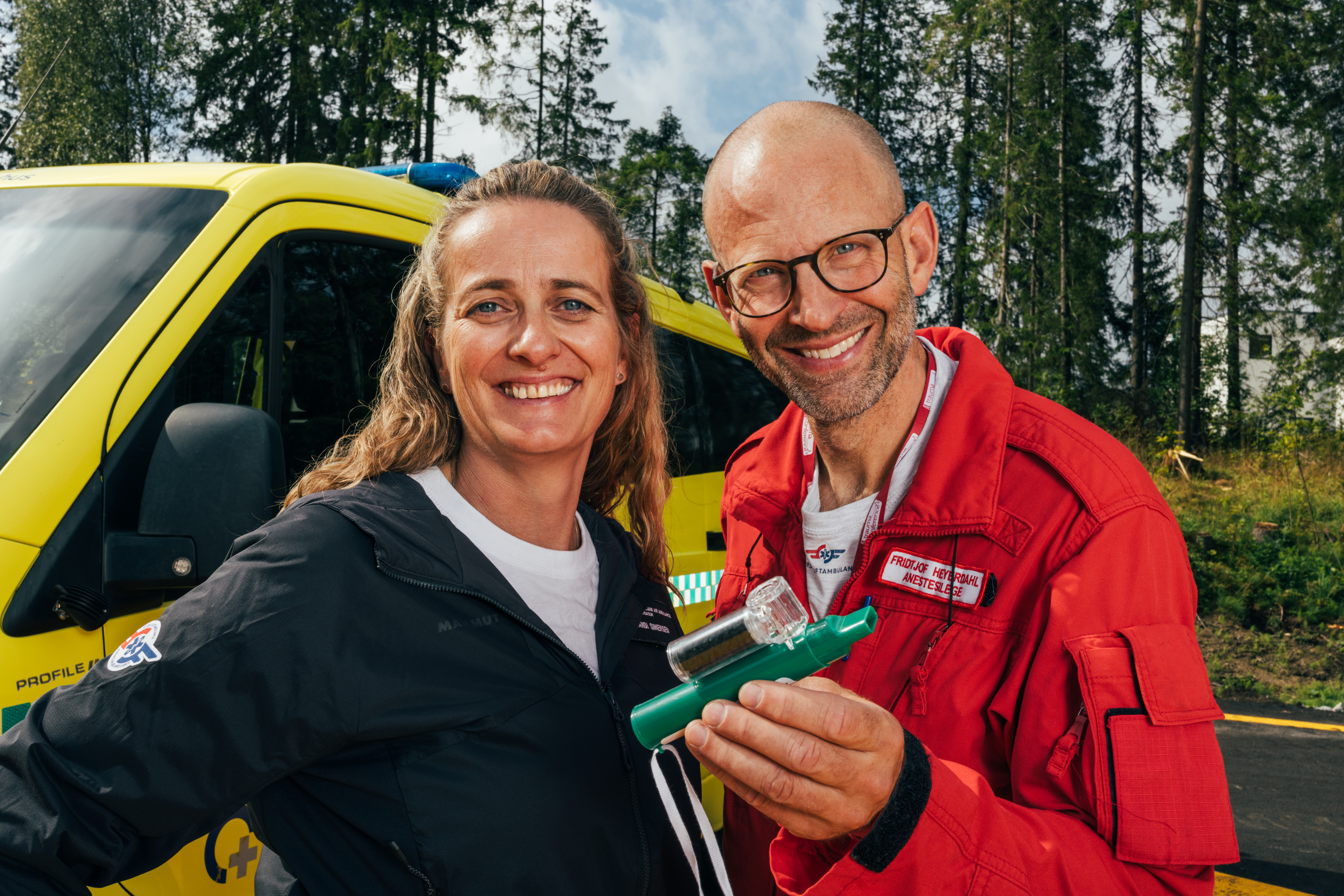 Bilde av to personer utenfor en ambulanse som holder medisinsk utstyr