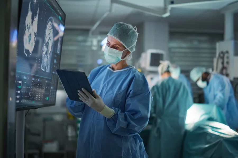 En mann med maske og en maske som holder en tablett