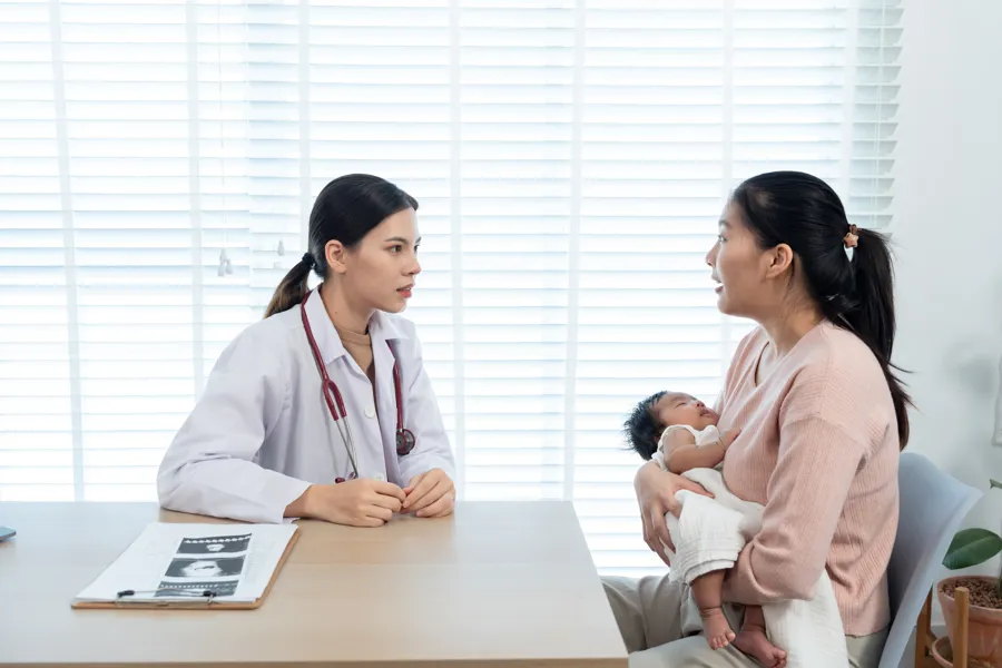 Mor med baby snakker med lege