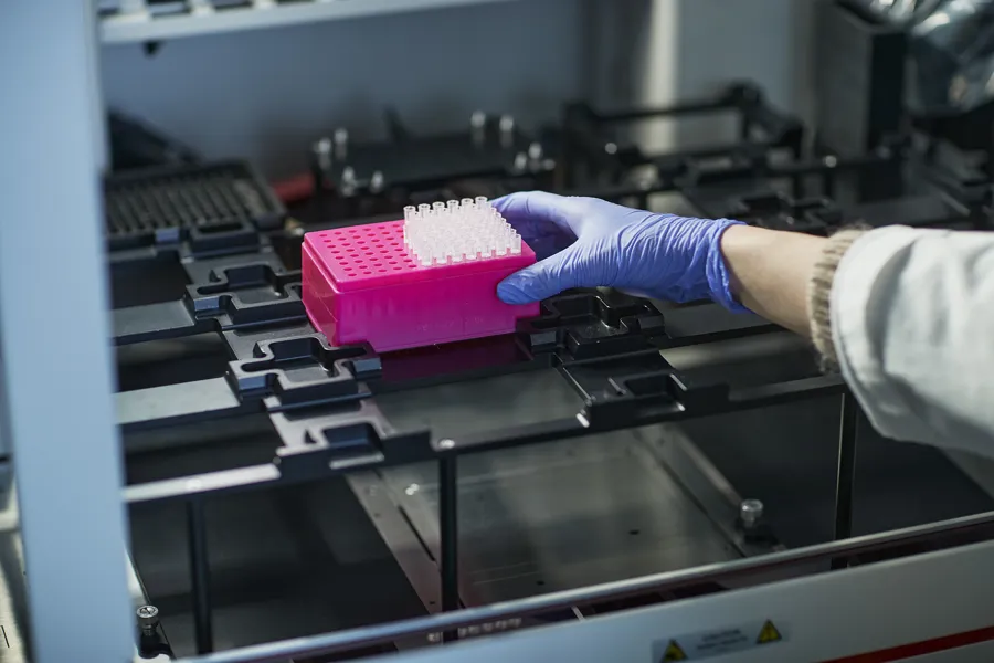 En person som bruker hansker og hansker som arbeider på en maskin