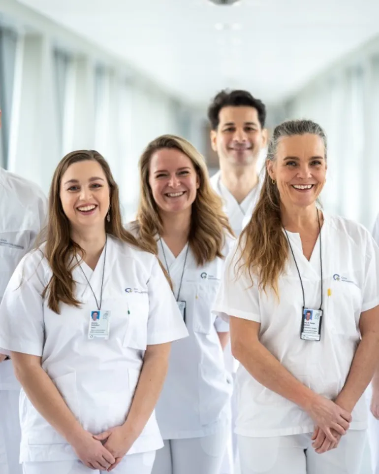 A group of people wearing white lab coats and badges