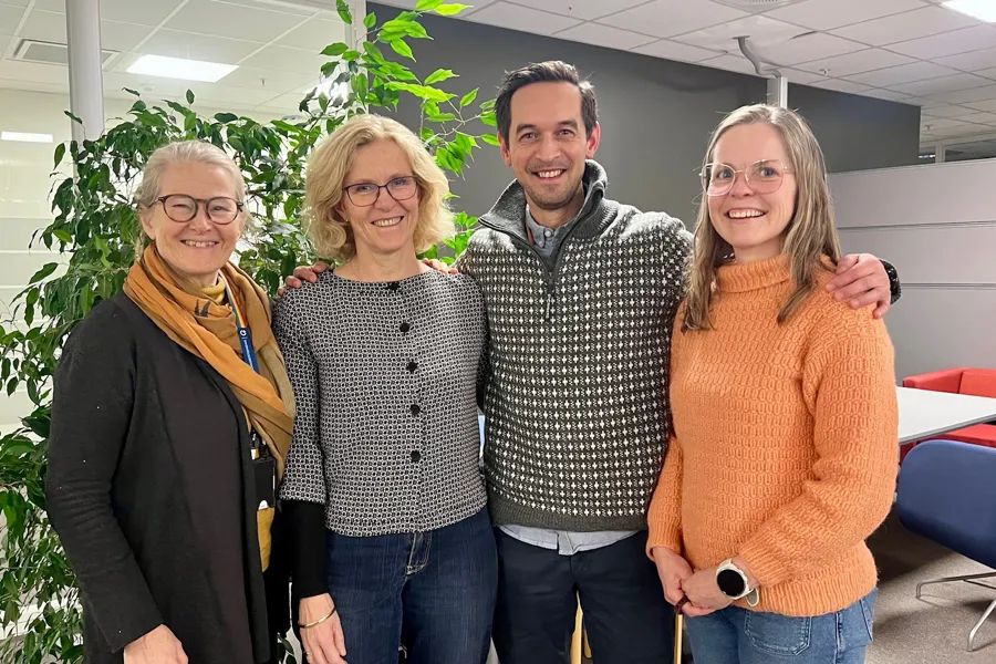 Kristin Bjordal, Cecilie Delphin Amdal, Kenth-Louis Hansen Joseph og Ragnhild Sørum Falk står inntil hverandre på kontoret og smiler mot kameraet.