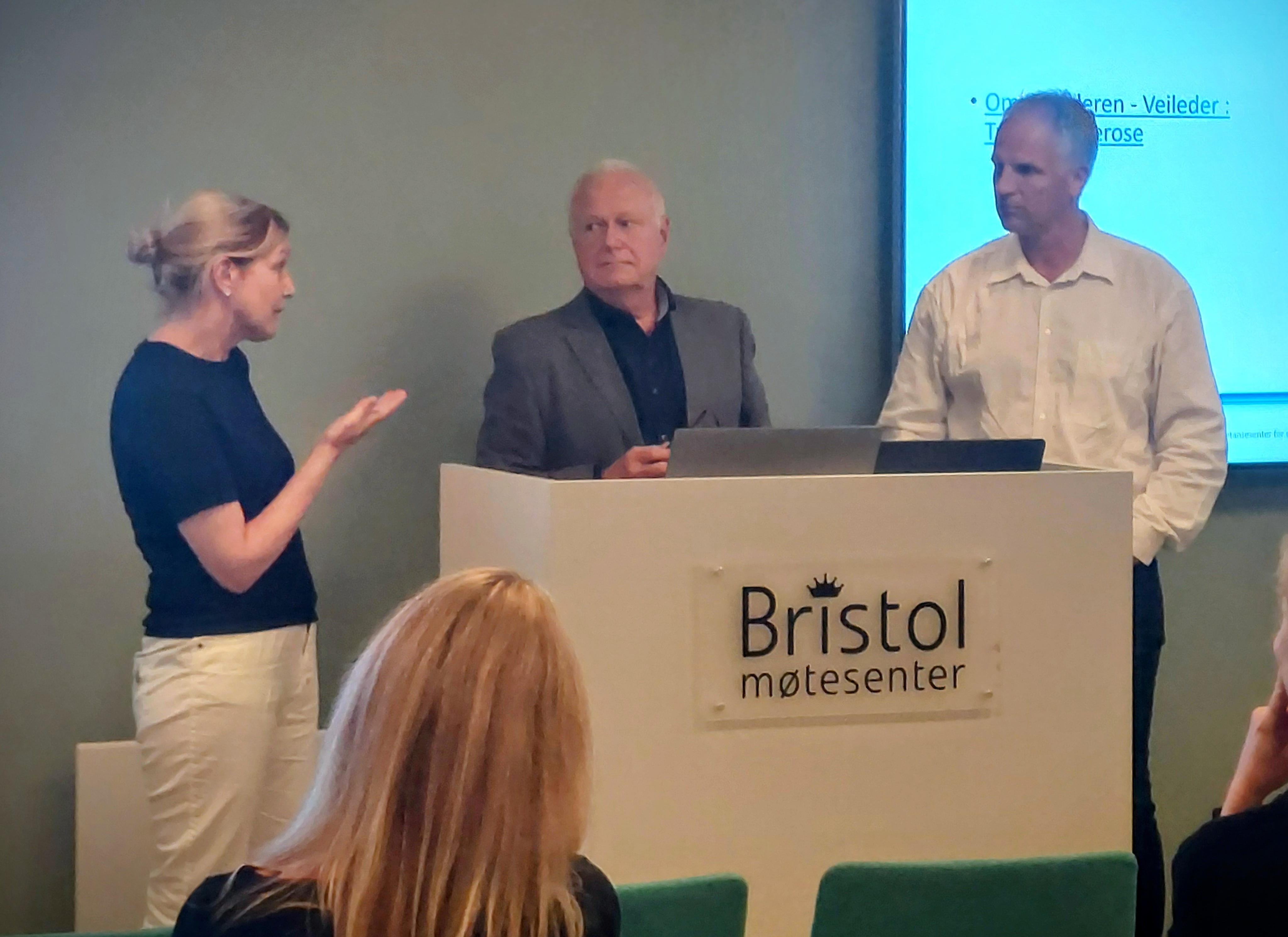 En gruppe mennesker som står på et podium