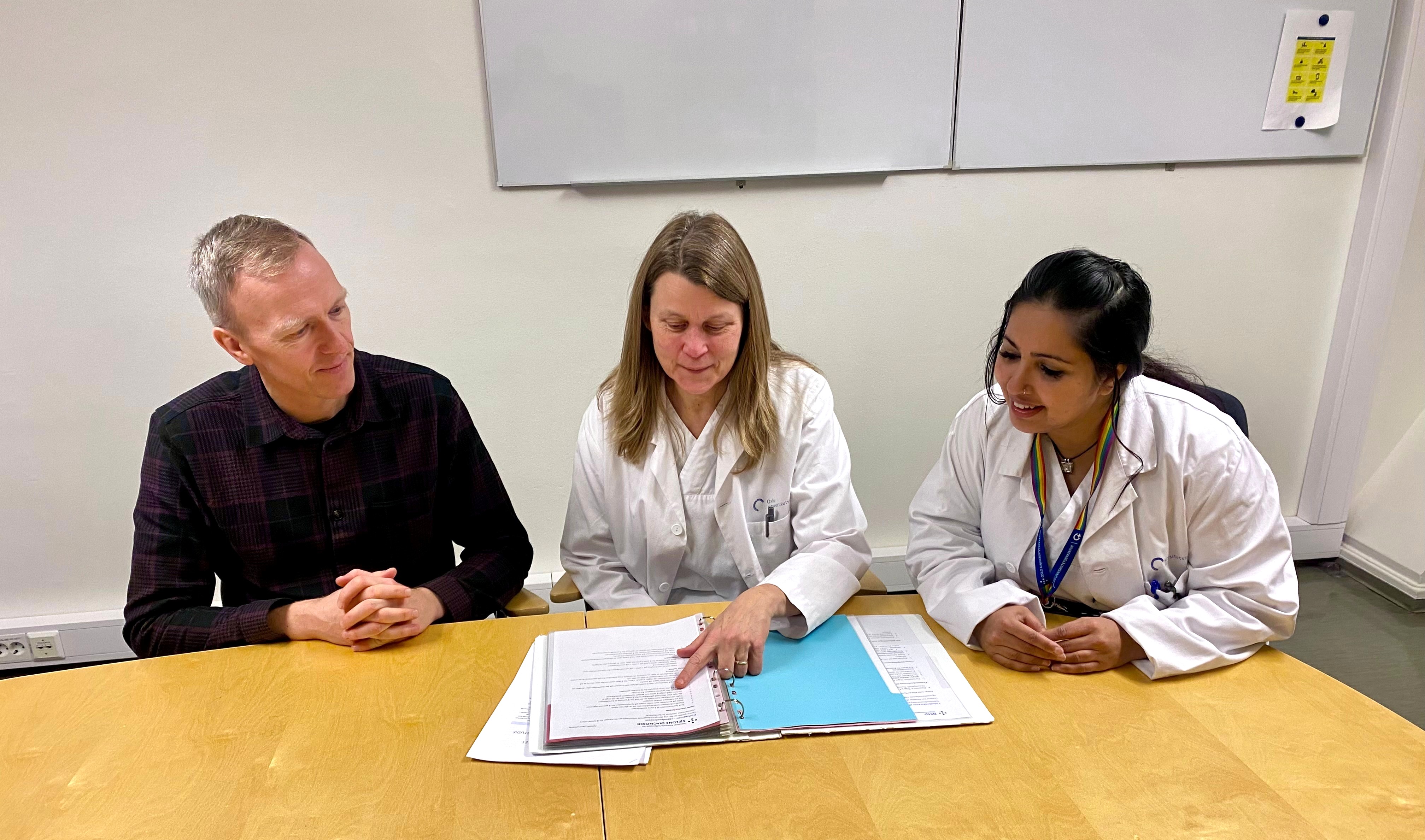 A group of people sitting at a table looking at a paper