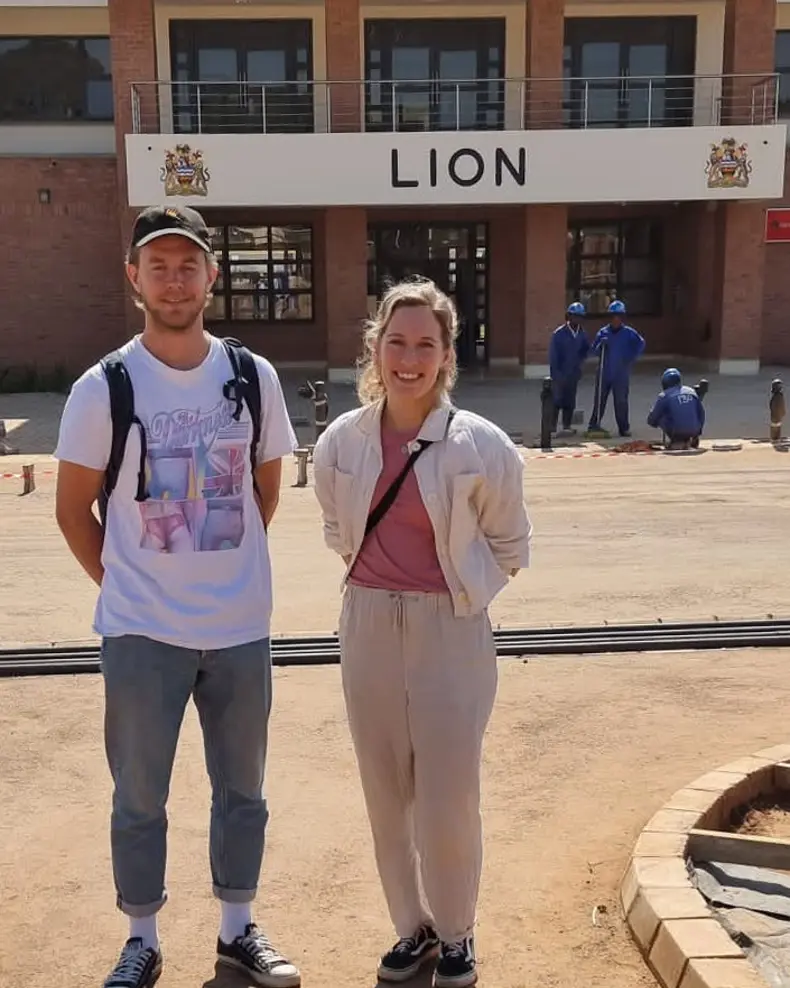 Kristoffer og Aina som poserer for et bilde foran en bygning