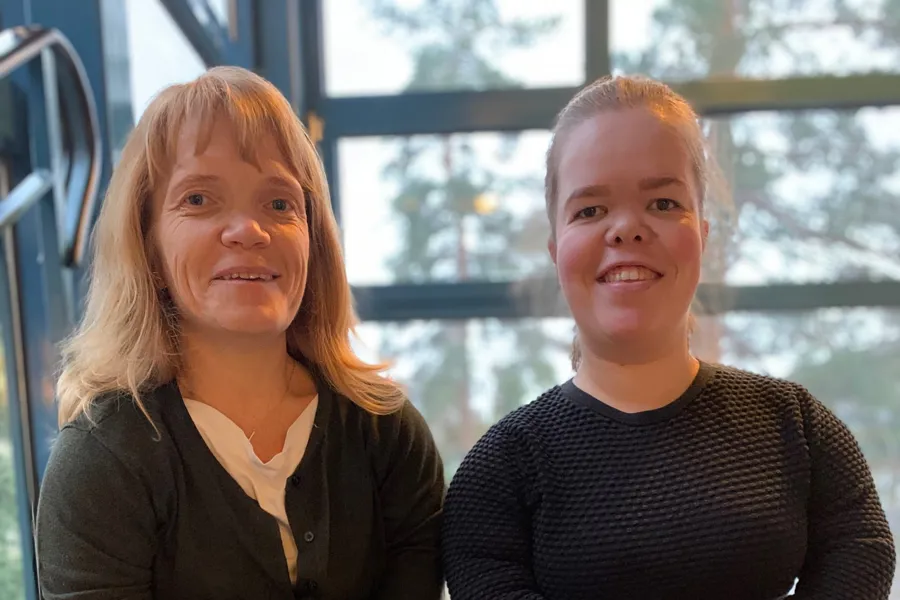 To jenter som sitter på en benk