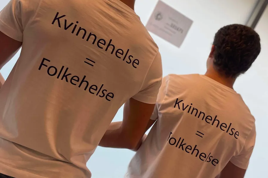 Et par menn iført t-skjorter med skrift på