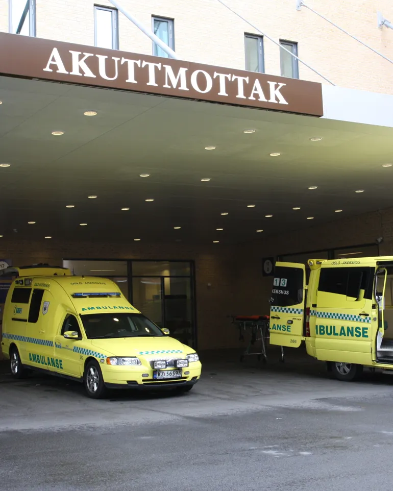 Et par gule ambulanser parkert utenfor en bygning