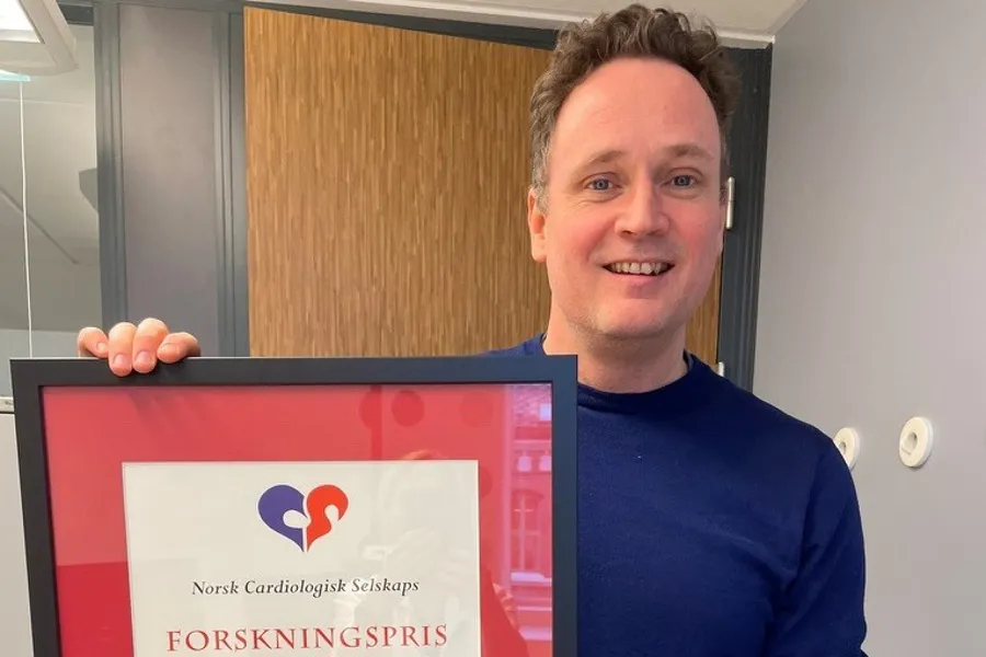 Portrettbilde av Lasse som holder prisbevis