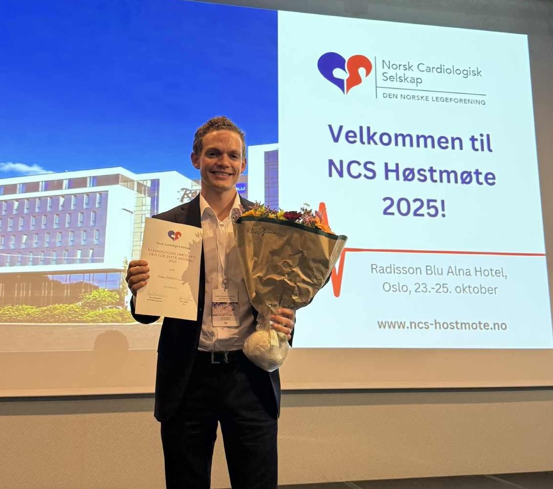 Bendik poserer på scenen med pris for beste abstrakt