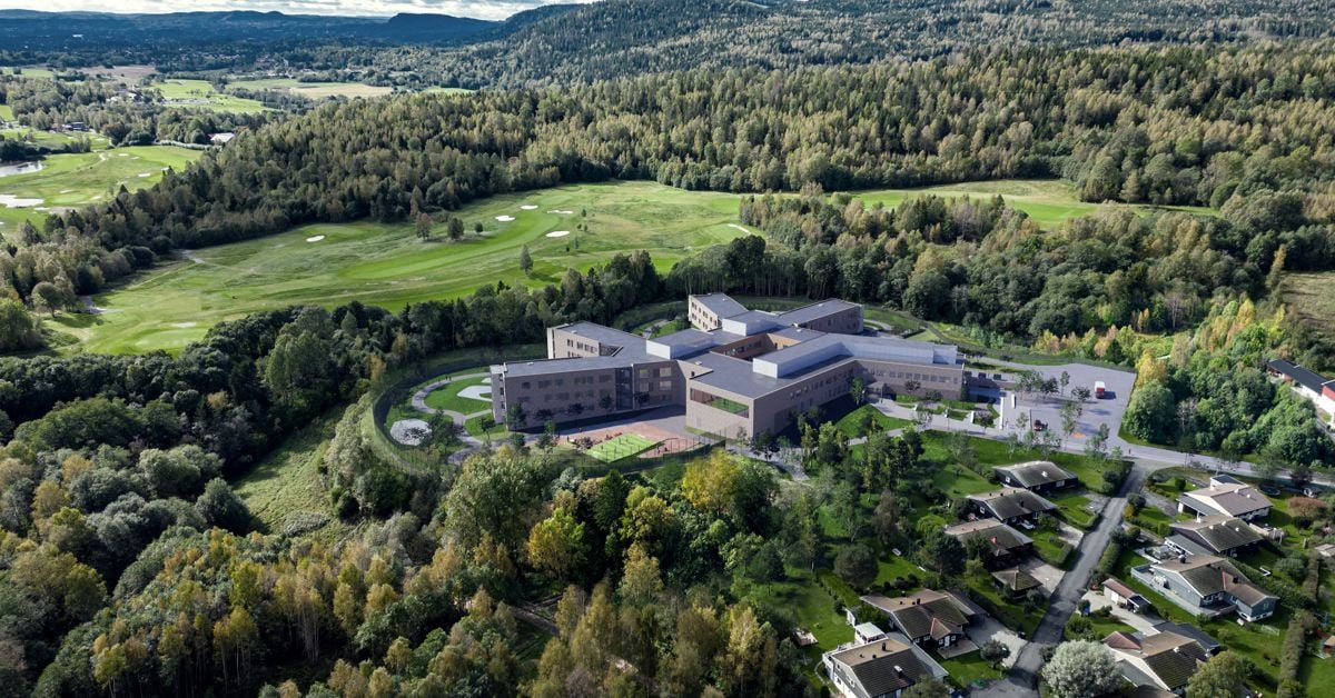 En stor bygning omgitt av grøntareal