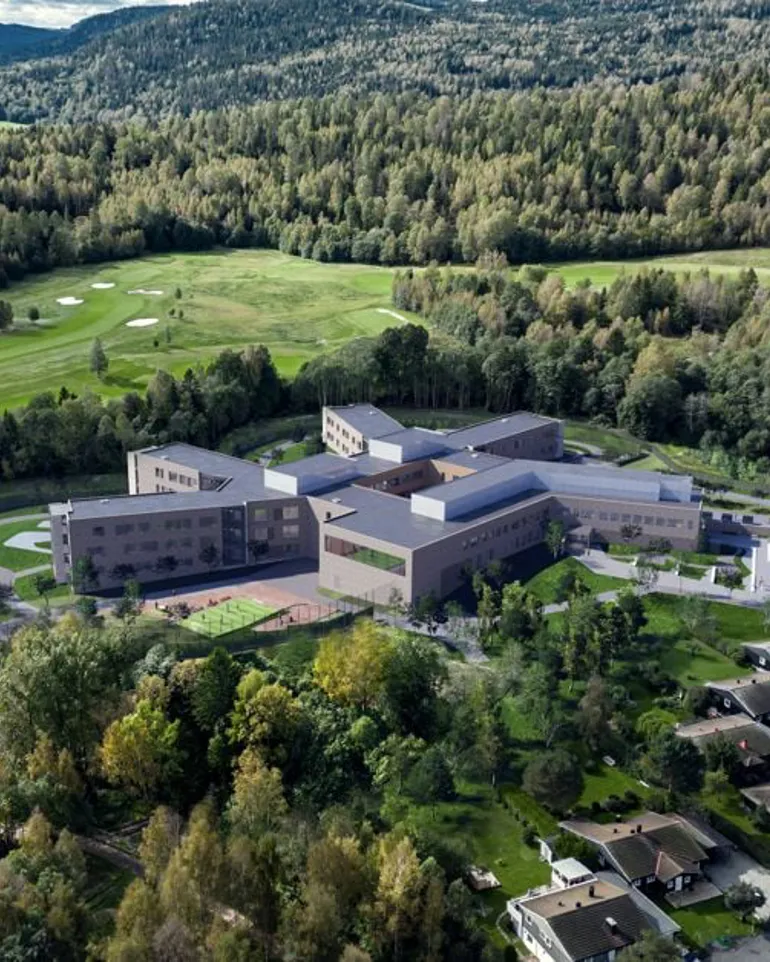 En stor bygning omgitt av grøntareal