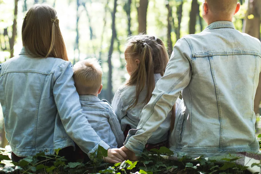 En gruppe mennesker som sitter i skogen
