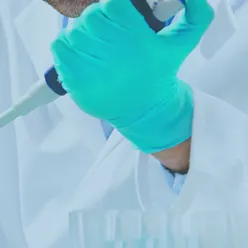 En person som har på seg maske og hansker