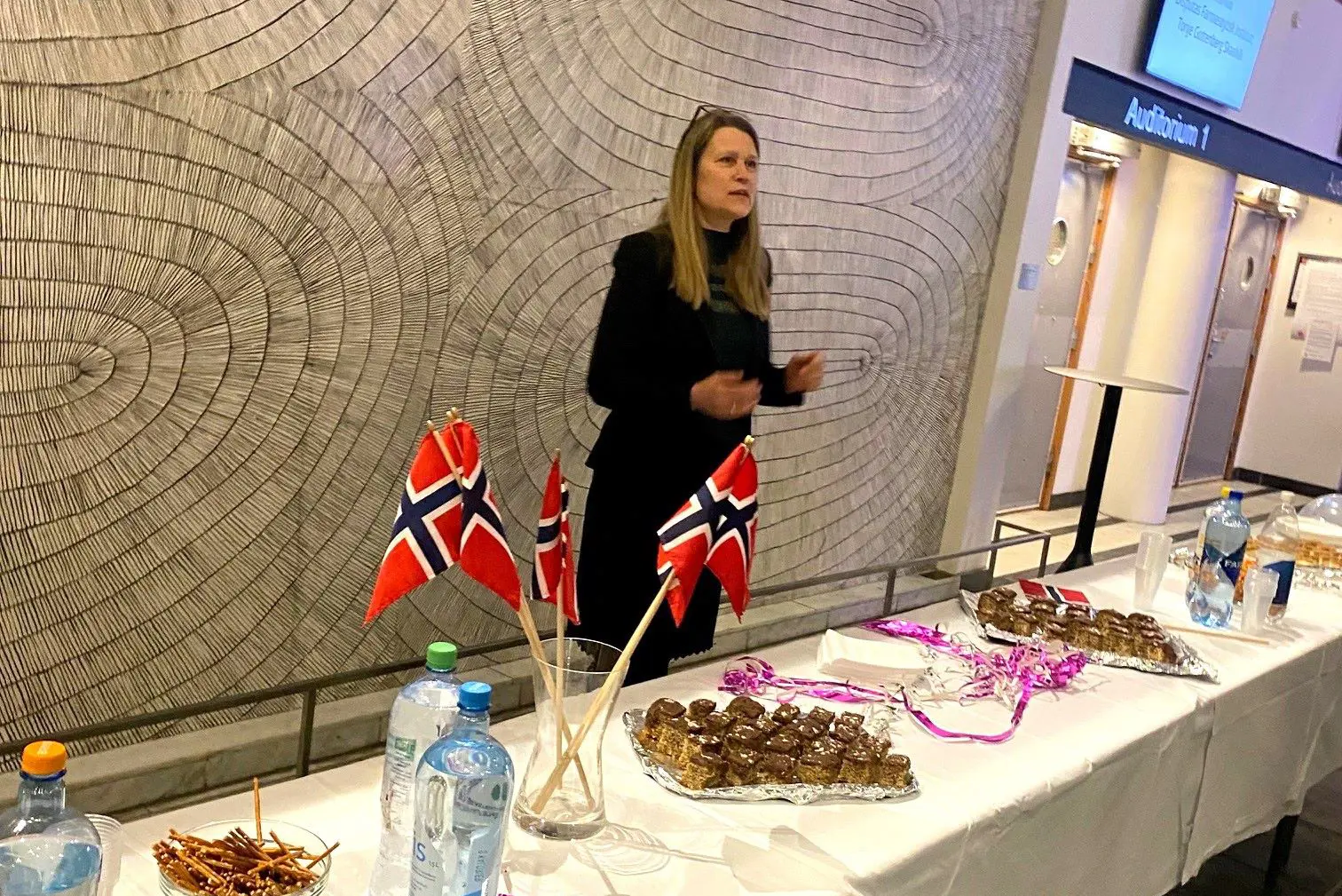 A person standing behind a table with food and drinks on it