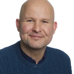 En skallet mann i svart skjorte