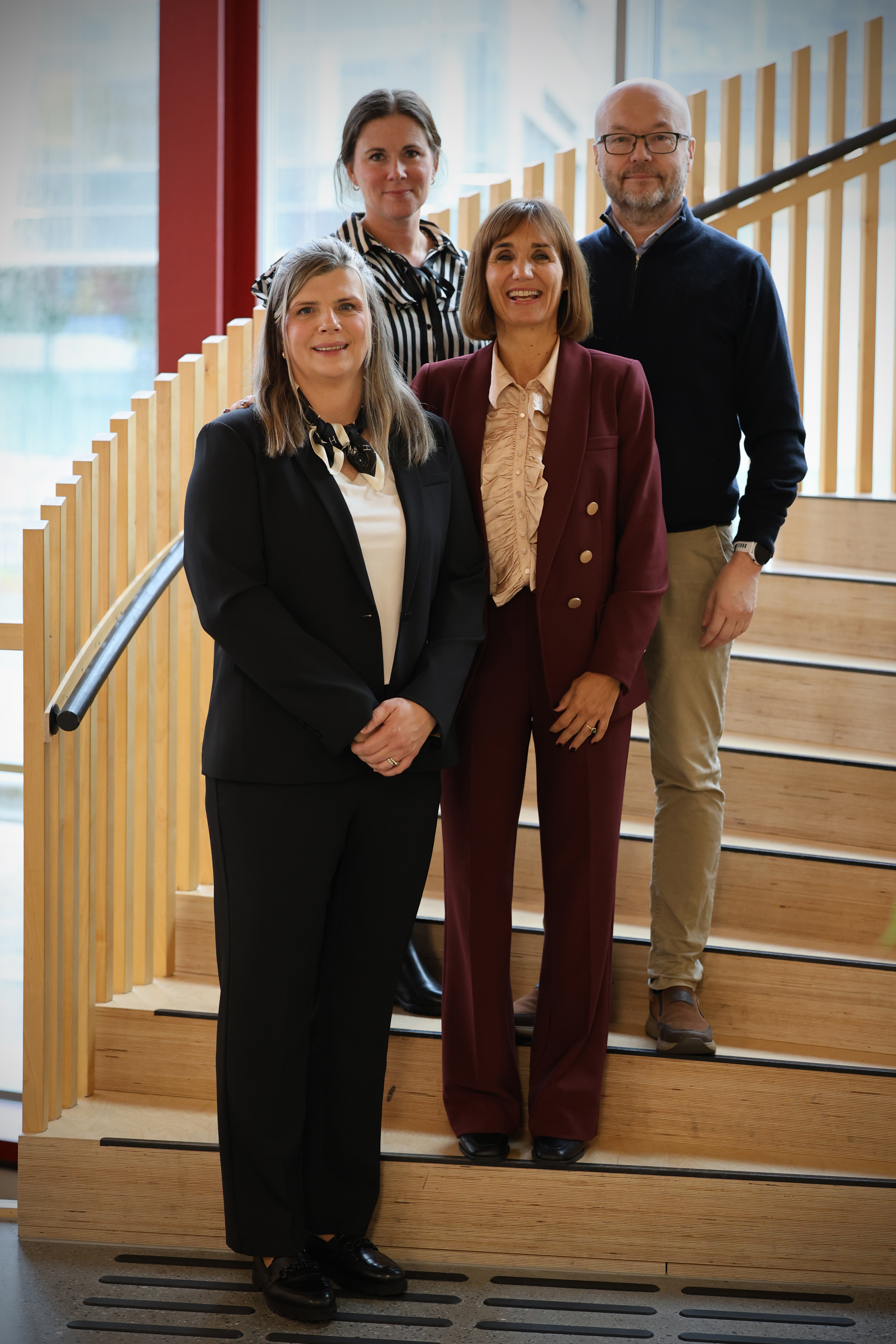 four people posing on the stairs for a picture
