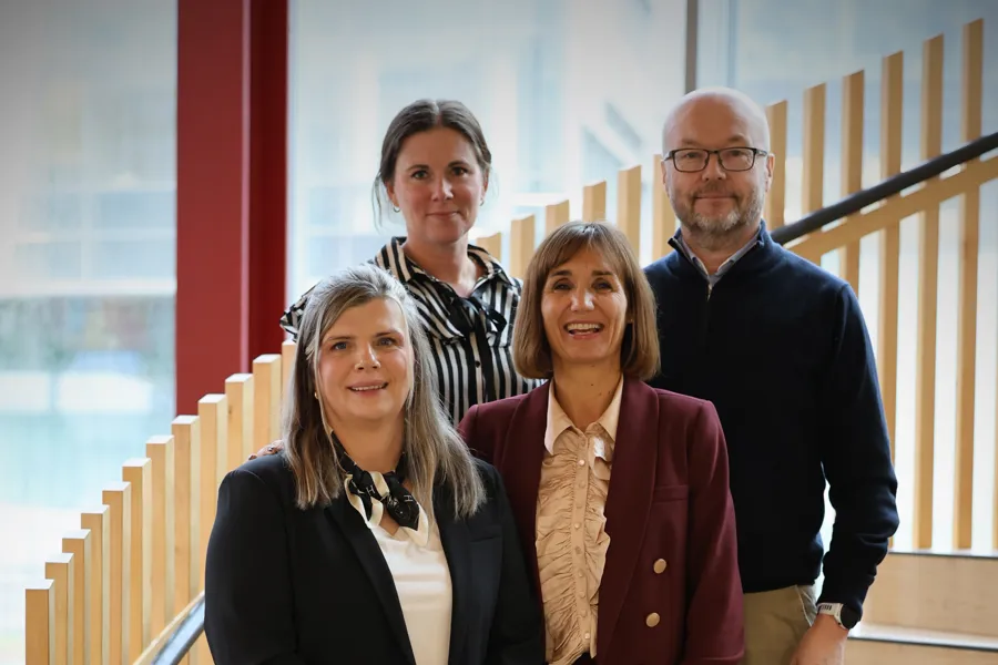 four people posing on the stairs for a picture