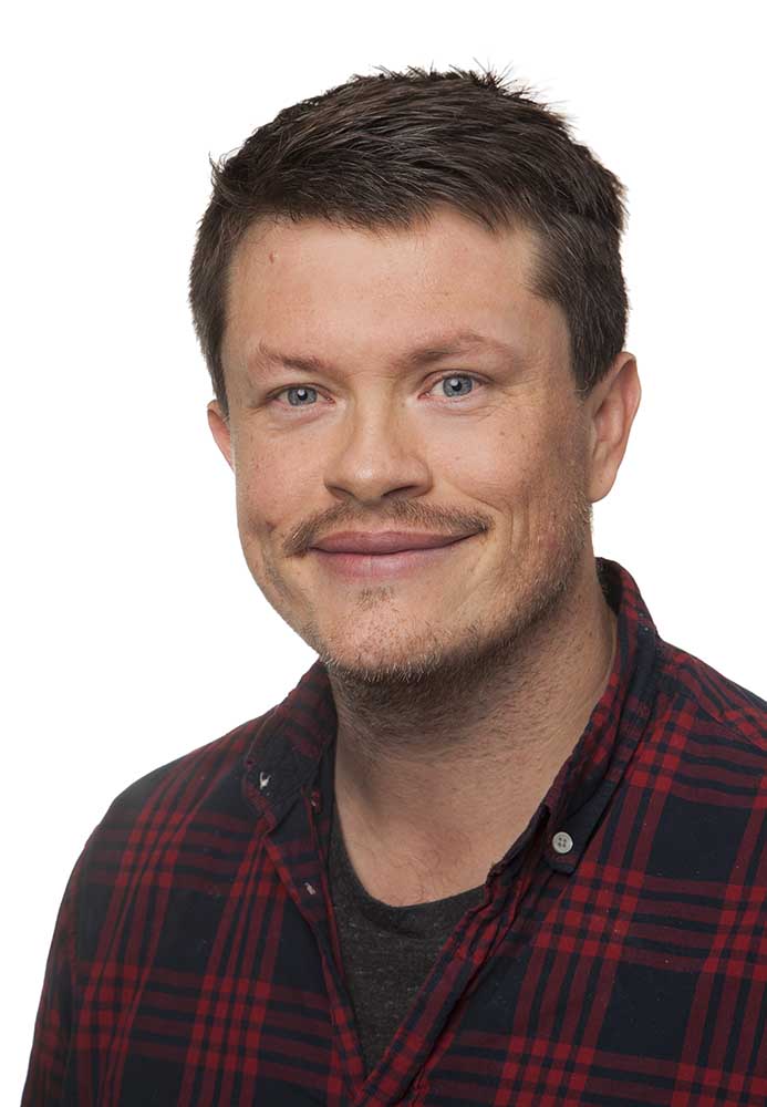 En mann som smiler til kameraet