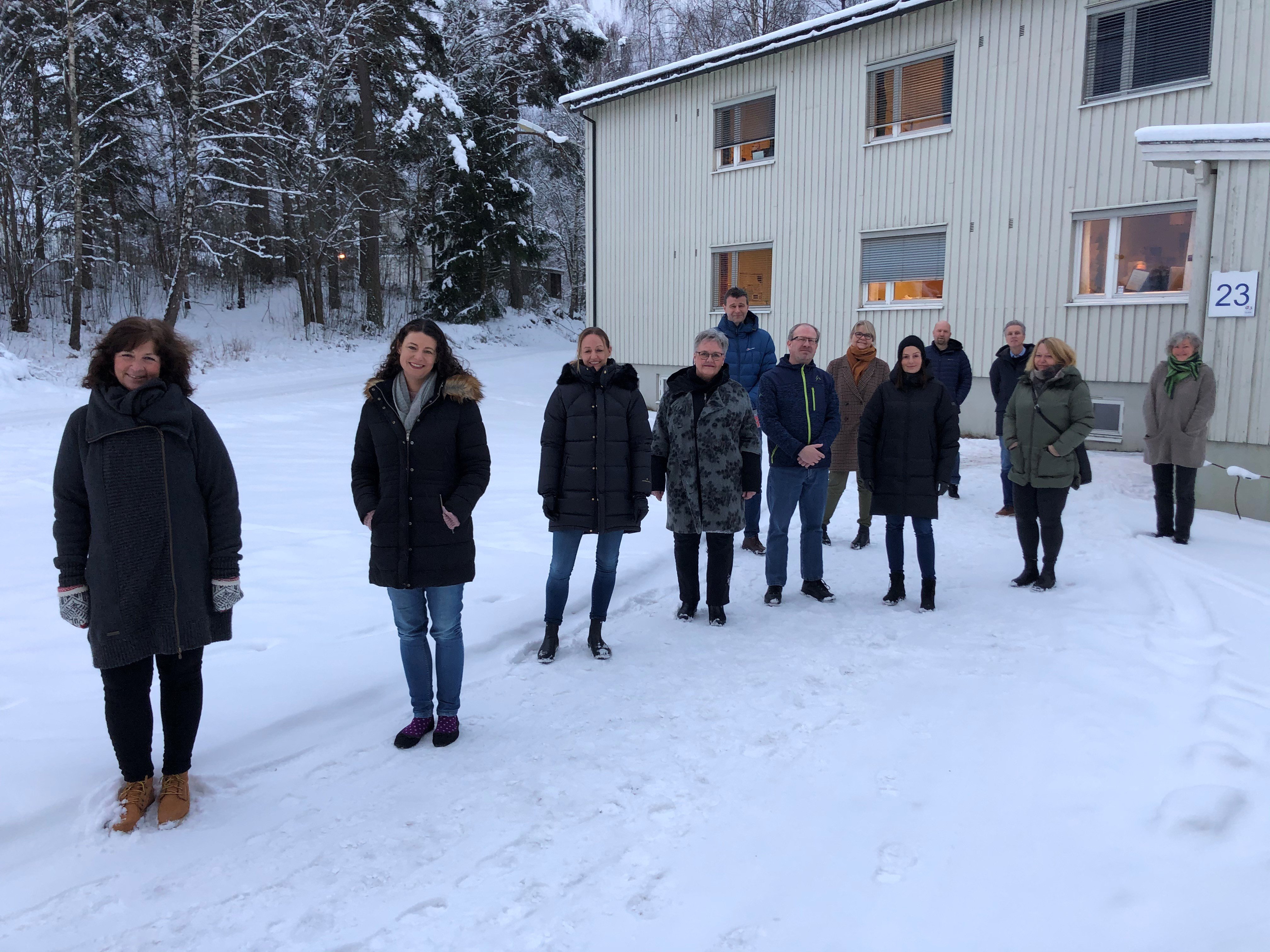 En gruppe mennesker som står i snøen