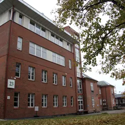 En murbygning med et tre foran seg