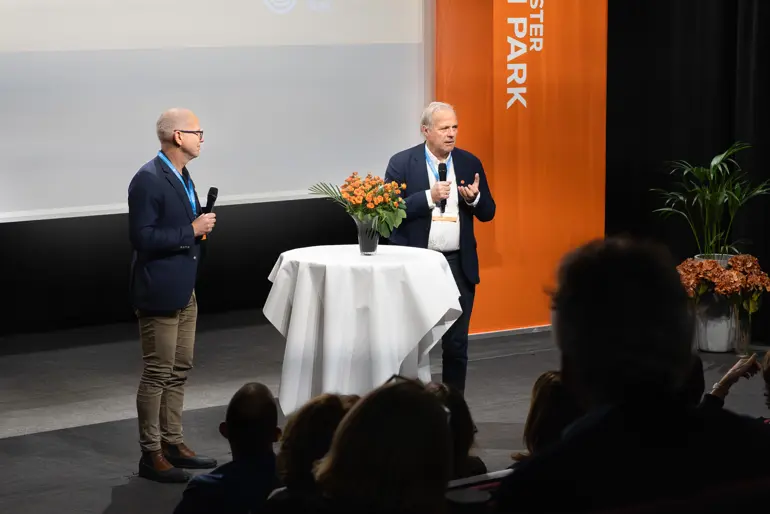 Et par menn som snakker til en folkemengde