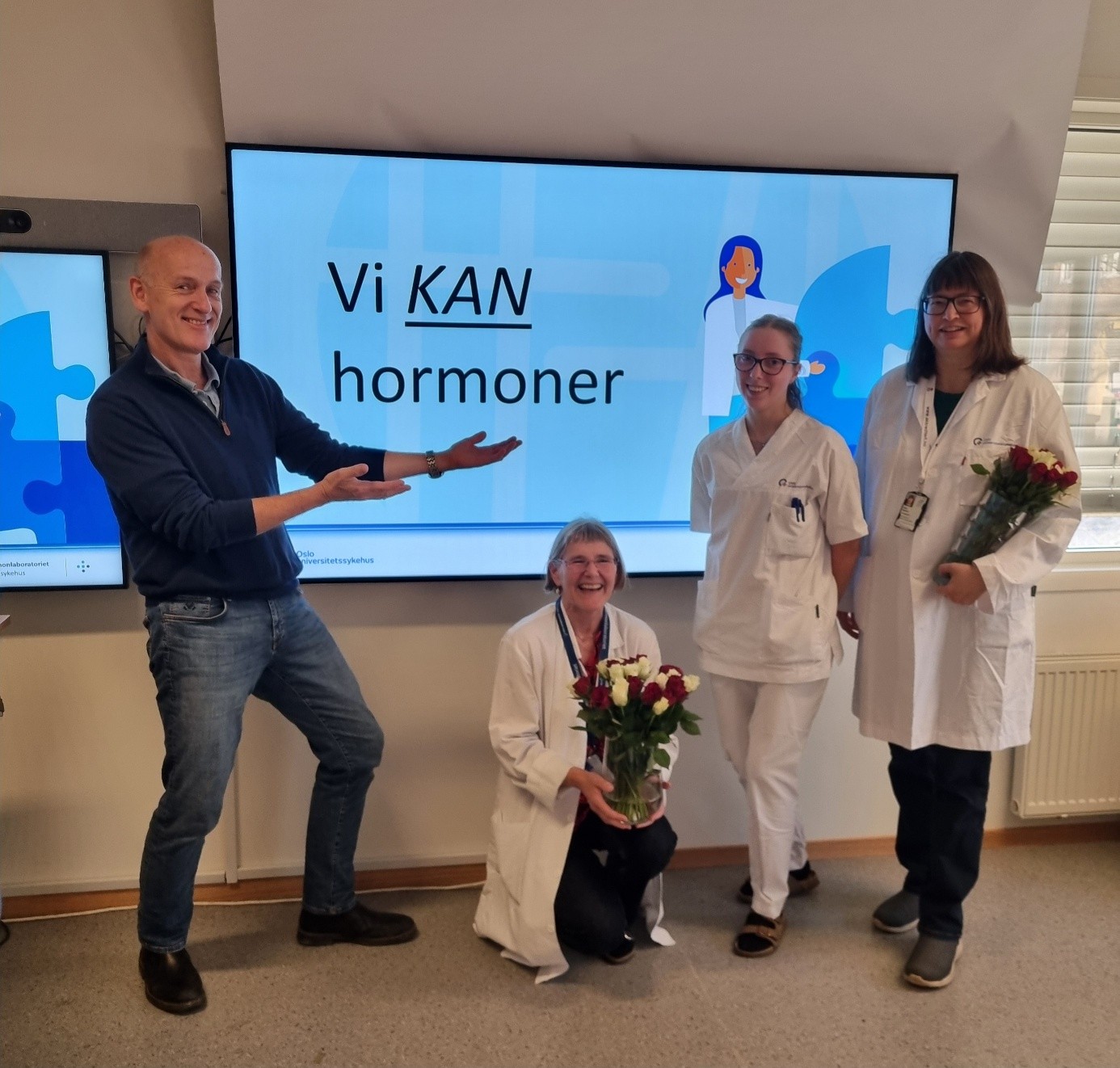 En gruppe mennesker som står foran en skjerm