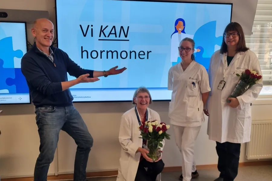 En gruppe mennesker som står foran en skjerm